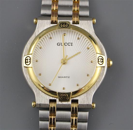 A modern stainless steel and yellow metal Gucci quartz dress wristwatch, on steel and yellow metal bracelet,